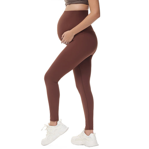 Brown leggings worn by a Pregnant person on a white background